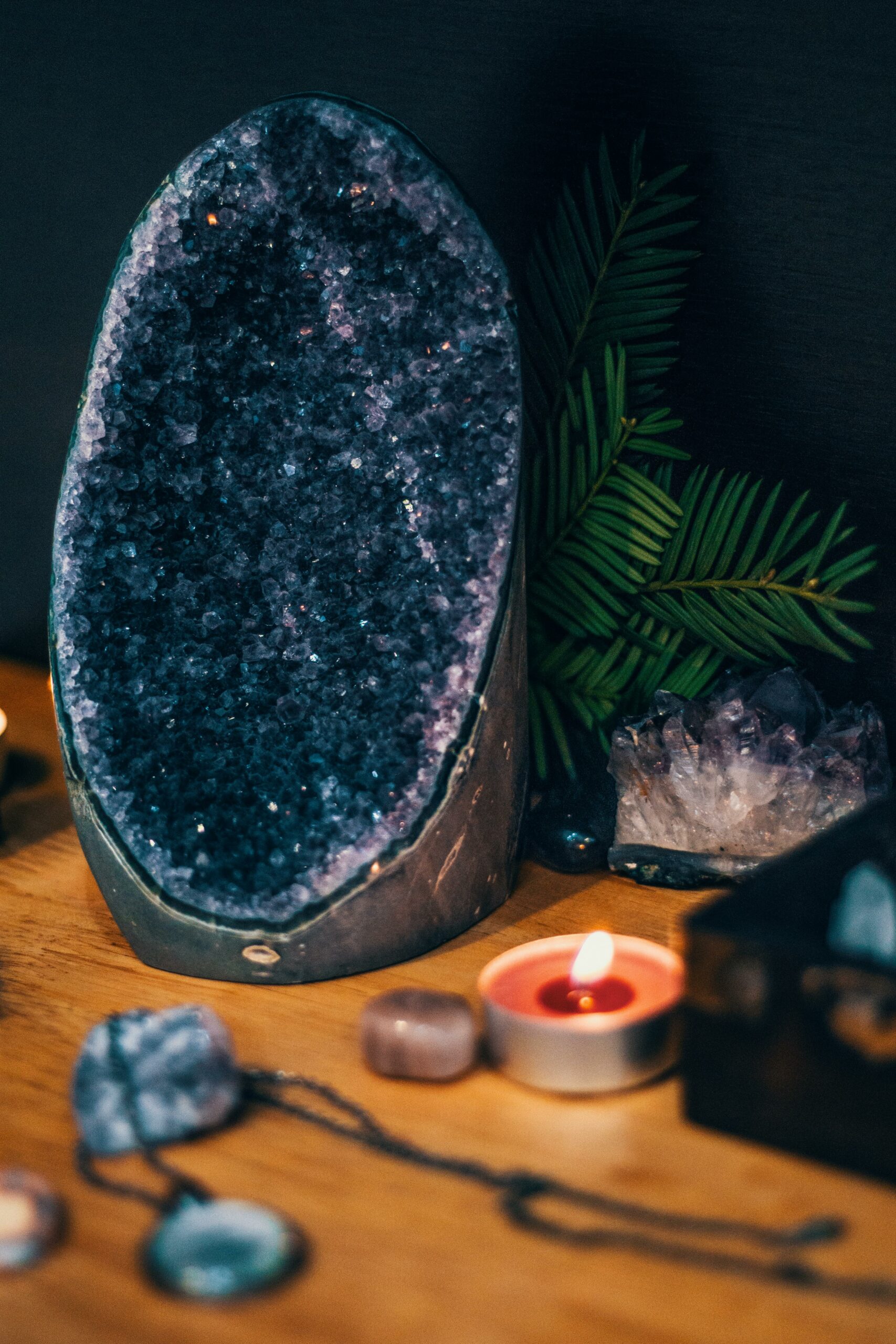 Serene scene with a large amethyst geode, teardrop candles, and lush greenery. Perfect for spa and relaxation themes.